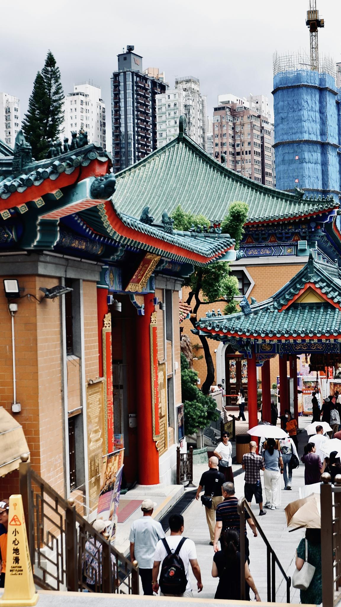 Explore the bustling architecture and cultural atmosphere of Wong Tai Sin Temple in Kowloon, Hong Kong.